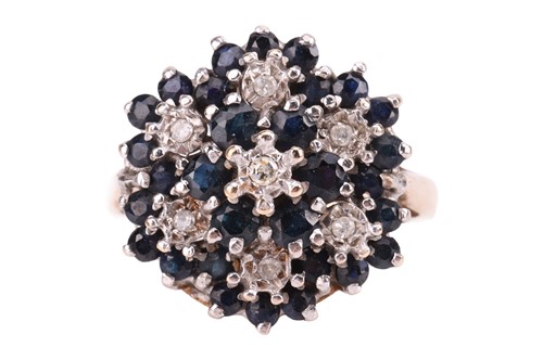 Lot 126 - A sapphire and diamond cluster ring, in a claw...