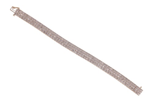 Lot 181 - A hinged bracelet, featuring three rows of...