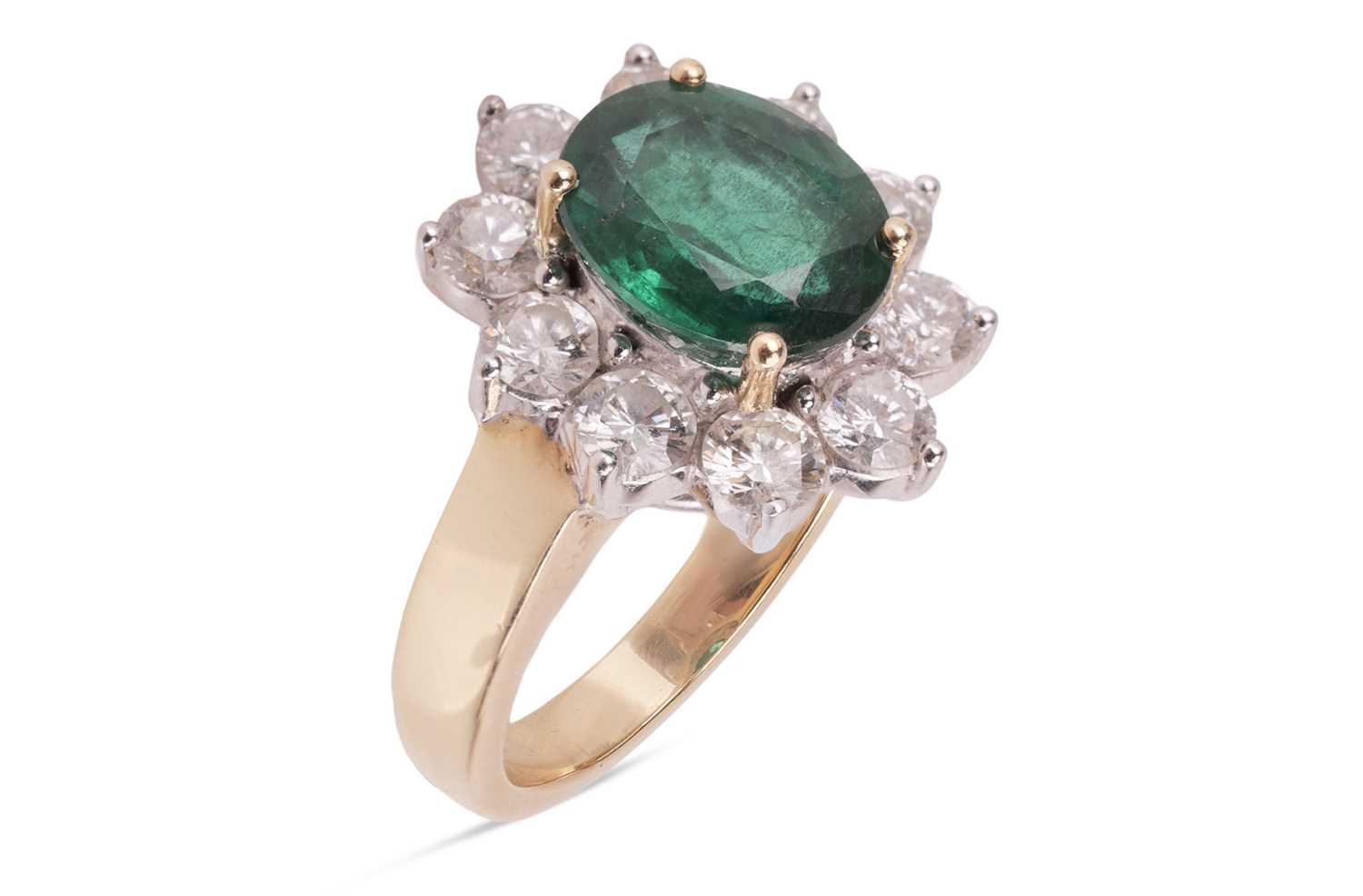 Lot 198 - An emerald and diamond cluster ring, featuring...