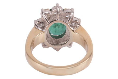 Lot 198 - An emerald and diamond cluster ring, featuring...