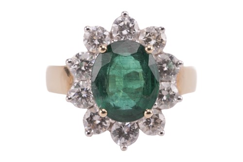 Lot 198 - An emerald and diamond cluster ring, featuring...