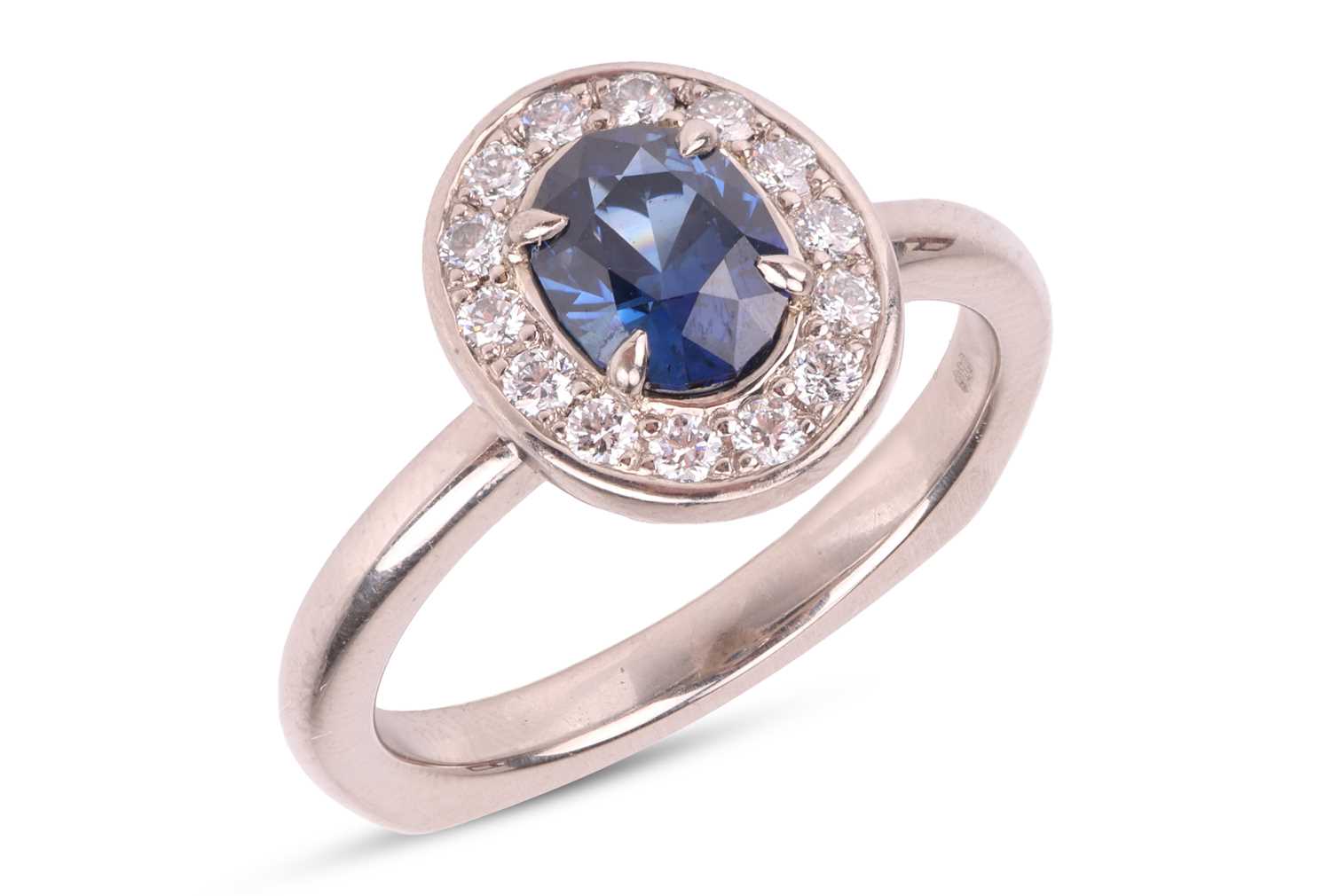 Lot 135 - A sapphire & diamond cluster ring, featuring a...