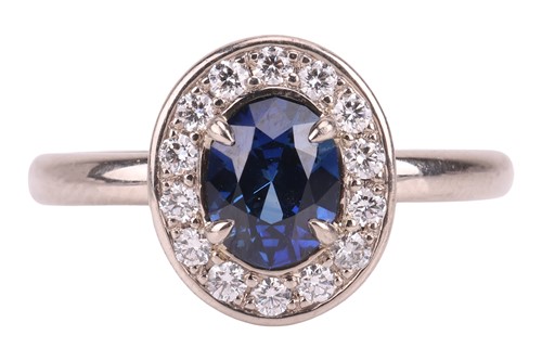 Lot 135 - A sapphire & diamond cluster ring, featuring a...