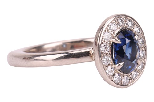 Lot 135 - A sapphire & diamond cluster ring, featuring a...