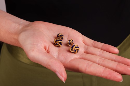 Lot 62 - A pair of enamel knot cufflinks, the knot...