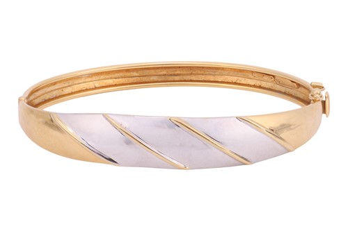 Lot A hinged bangle, of bi-colour striped design,...