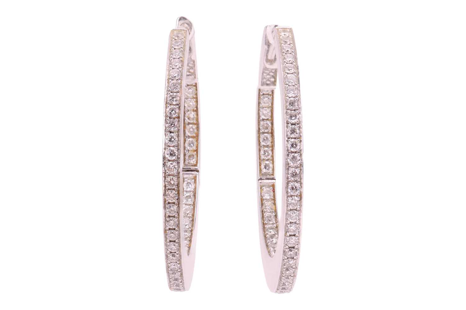 Lot A pair of diamond hoop earrings, set to the...