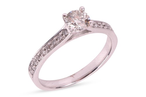 Lot A diamond solitaire ring, featuring a claw-set...