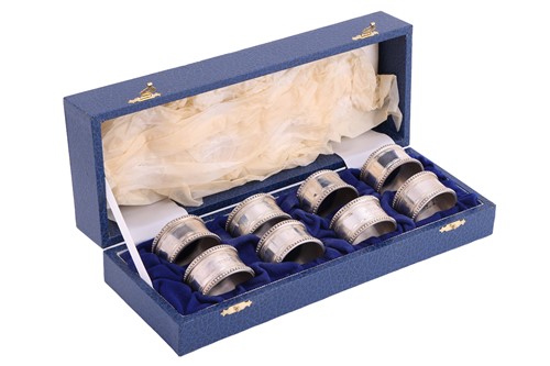Lot 222 - A cased set of eight silver napkin rings, by...