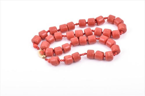 Lot 537 - A coral-coloured necklace comprised of thirty...
