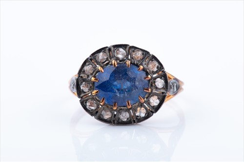 Lot 498 - A diamond and sapphire cluster ring set east...